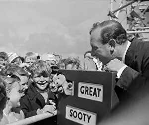 Harry Corbett and Sooty mobbed by fans at the Daily Mirror Beach party. August 1958