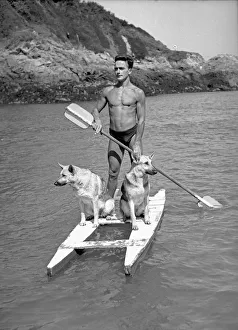 Coast Prints: Harry Ibbotson of Fermain Bay in Guernsey on his paddle boat with his two Alsatian dogs
