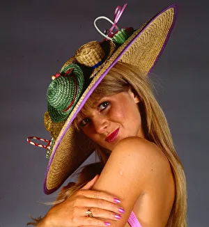 Hat fashion model wears straw hat July 1990 With miniature hats