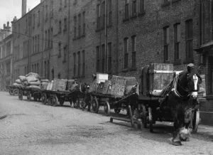 Carts Prints: Heavy horses with their carts wait to offload their deliveries in this un-named