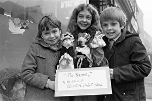 00523 Prints: Helme Junior School pupils arranging their Nativity scene in the window of a Meltham