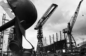 Landscape Prints: A helmet hanging with welders goggles amongst the empty cranes after the closure of Govan