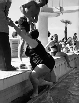 Helping Hands A large lady is helped out of the outdoor swimming pool at Plymouth
