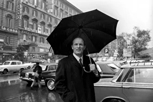 Henry Cooper in Italy: Henry Cooper pictured in the rain on the Via Veneto