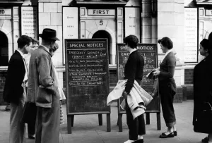 00538 Prints: Holiday makers study notices giving details of the emergency rail services to Snow Hill