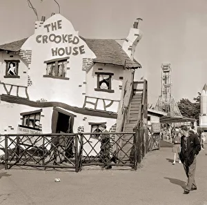 Fairground Rides Prints: Holiday Resorts at Southend in Essex A man walks by a themed house called
