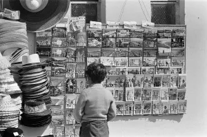 East Sussex Prints: Holiday scenes in Brighton, East Sussex on the Whitsun bank holiday - a little boy looks