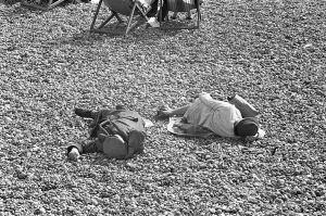 Holiday scenes at Brighton. Two elderly holidaymakers sleeping on the beach after