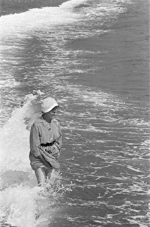 Waves Prints: Holiday scenes at Brighton Elderly woman paddling in the sea holding her skirt up