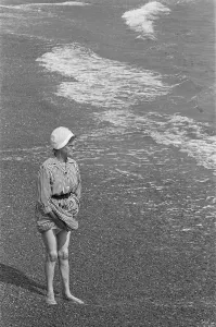 00960 Prints: Holiday scenes at Brighton Elderly woman paddling in the sea holding her skirt up