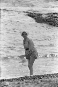 East Sussex Prints: Holiday scenes at Brighton Elderly women paddling on the beach holding her skirt