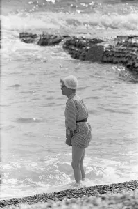 00960 Prints: Holiday scenes at Brighton Elderly women paddling on the beach holding her skirt
