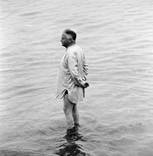 Alone Prints: A holidaymaker paddles in the sea on the beach at Margate during the Summer holidays