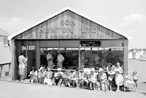 00170 Prints: Holidaymakers enjoy the sunshine as they sit outside a betting shop in the form of a