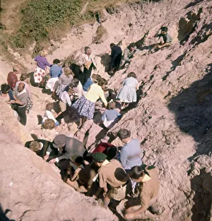 00267 Prints: Holidaymakers scratching out the coloured sands from the cliff face at Alum Bay