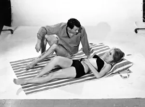 Holidays: Man and Woman demonstrating the beach bag that converts into a beach mat
