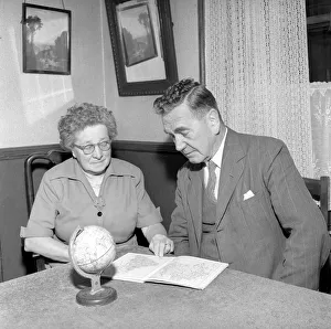 00091 Prints: Holidays: Pensioners seen here looking at the globe deciding where to go to for their