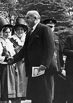 Minister Prints: Home Secretary David Maxwell Fyffe greets a woman in national dress at the Welsh