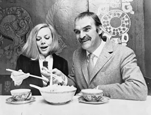 Honor Blackman and Stanley Baker eating food with chopsticks in Chinese restaurant