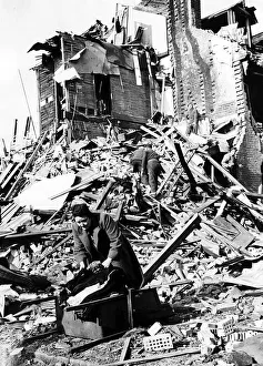 Struggle Prints: Housewife Mrs Berbiest gathers her belongings from the remains of her home