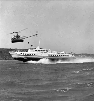 Chopper Prints: The Hydrofoil Condor 1 at sea of Jersey, overhead is a small helicopter