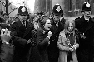 Two hysterical, weeping girls are led away from the steps of the register office by