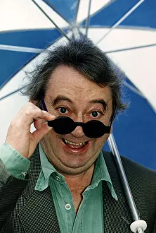 01031 Prints: Ian McCaskill Peering over the rim of a pair of sunglasses holding umbrella C / photo