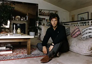 Imran Khan Cricket sitting on floor in living room in front of sofa at his home
