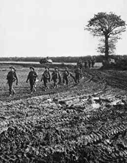 01446 Prints: Infantry moving across country and down muddy tracks en route for Geilenkirchen