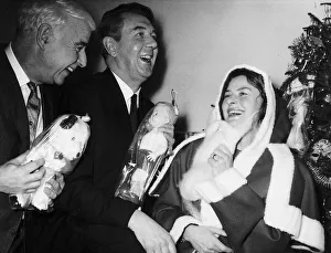 Ingrid Bergman actress puts on a Father Christmas outfit much to the amusement of Sir