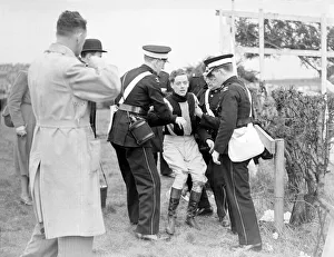 First Aid Prints: Injured jockey R Curran (Ulster Monarch) is helped to his feet in The Grand National