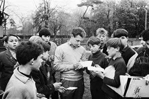 Autograph Prints: Injured Liverpool footballer Gordon Milne signs autographs for young fans as his