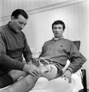 Injured Liverpool player Tommy Smith receives treatment from Bob Paisley in the treatment