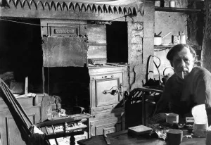 00054 Prints: The Interior of slum housing in an area of Newcastle - Mr George Marshall sits in his