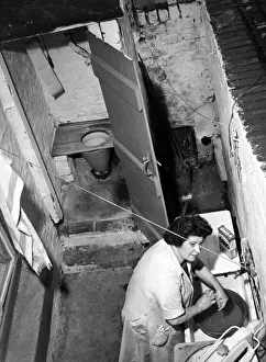 Laundry Prints: Interior view of a Liverpool terraced house showing a woman scrubbing her hands in
