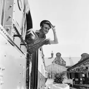 Isle of Man TT Races. Rider Mike Hailwood wearing a drivers cap on a Manx train
