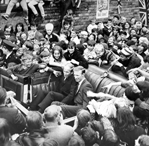 Jack and Bobby Charlton look over-awed as youngsters crowd around the car taking them to