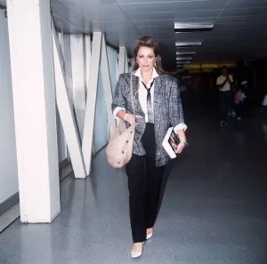 Obit Prints: Jackie Collins arriving at Heathrow with her new book September 1985