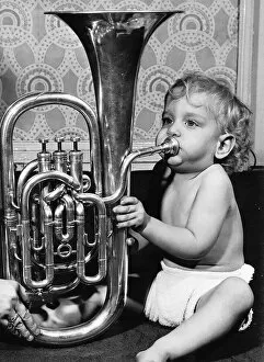Images Dated 19th April 1977: James Houlsby eighteen months old, playing the euphonium