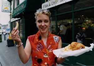 00127 Prints: Janice Forsyth TV presenter in Rothesay fish chips supper orange shirt