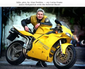 Janice Kirkpatrick top designer with her yellow Ducati 748 motorcycle