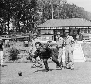 Japanese rider Shimazaki playing bowls with his team of mechanics watching