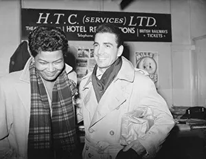 Raincoat Prints: Jazz singer Pearl Baily seen here with drummer Louis Balassone 16th November 1952