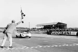 Steward Prints: Jim Clark takes the checkered flag in his Lotus 23 to win the Martini Rossi Trophy race