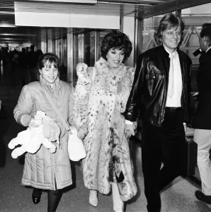 Joan Collins with daughter Katyana Kass and boyfriend Peter Holm at Heathrow after