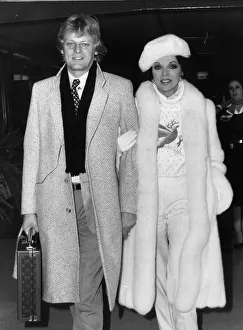 Ties Prints: Joan Collins at Heathrow Airport with boyfriend Peter Holm. December 1984