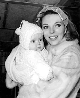 01415 Prints: Joan Collins holding baby daughter Tara at London Airport - February 1964