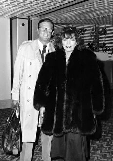 Images Dated 18th July 1988: Joan Collins and Roger Moore at Heathrow airport, July 1988
