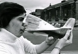 Joe Bailey drinking from a giant glass boot that he bought in Germany that holds 4 1 / 2