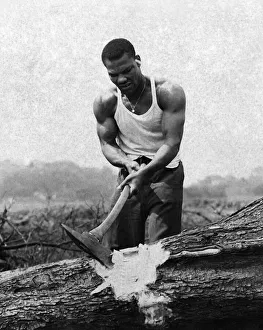 Joe Bygraves in a serious mood chopping up a large tree trunk on a nearly farm in Upton